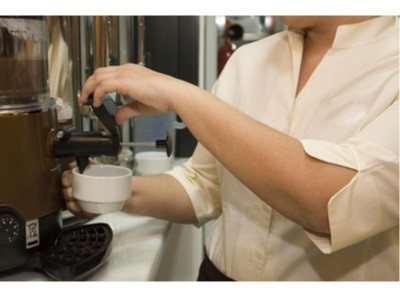 Un camarero preparando un café en un bar